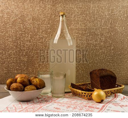 Ukrainian National Drink And Snack. The Big Bottle And Glass Of Moonshine On The Old Wooden Table