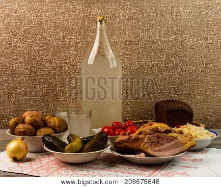 Ukrainian National Drink And Snack. The Big Bottle And Glass Of Moonshine On The Old Wooden Table
