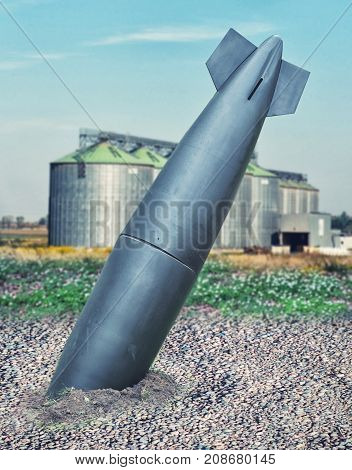 close up on misfire or unexploded bomb with the factory on background