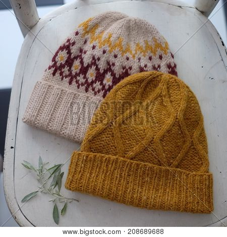 Two knitted tweed hats with a pattern on a white background