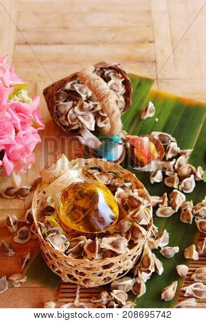 Moringa oleifera oil and seeds on wood background