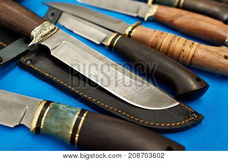 The forged hunting knives on blue background