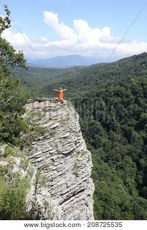 woman stands with his arms outstretched on Orlinye Rocks, Sochi, Krasnodar Territory