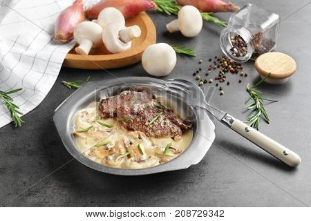 Plate with steak Diane on table