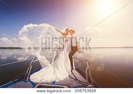 Couple Enjoying Sunset From The Deck Of The Sailing Boat Moving In A Sea