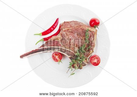 cibo di carne: arrosto nervatura sul piatto bianco con ramoscello di timo, pepe e pomodoro isolato su bianco energetic