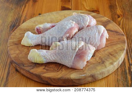 Raw Chicken Legs On Olive Wooden Board