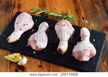 Raw Chicken Legs On A Black Slate