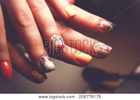 Perfect manicure and natural nails. Attractive modern nail art design. Gel polish applied. autumn drawing closeup