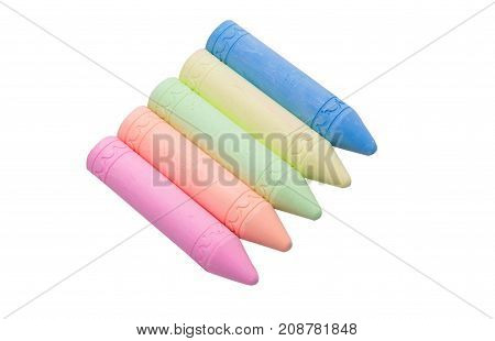 Sticks of pastel colored chalk casting shadow on white background.