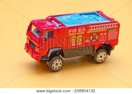 Red toy fire truck Toy fire engine extinguishes flaming house. Careless handling of fire dangerous for life