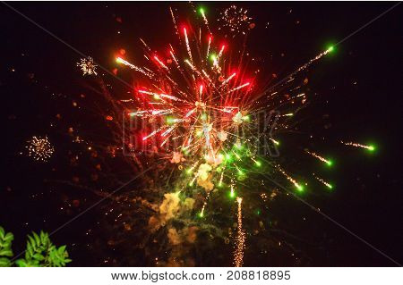 A photo of a salute in the night sky. Bright texture of festive fireworks. Abstract holiday background with various colors fireworks light. New Year's