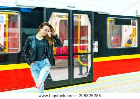 The girl near subway train at the metro station