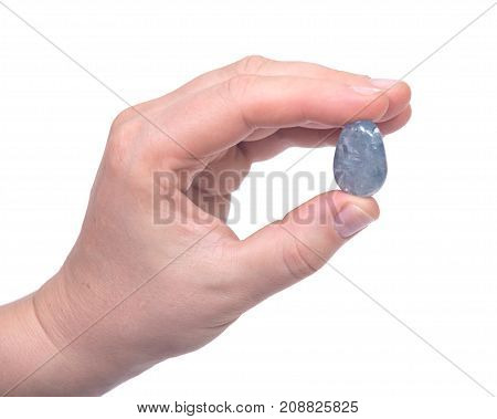 Woman's hand holding blue celestite polished palm stone isolated on white background