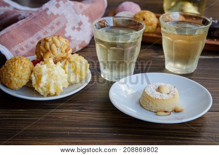 Panellets different Catalan small cakes served with sweet white wine . Typical sweets consumed at All Saints Day Dia Todos Los Santos in Catalonia Spain.