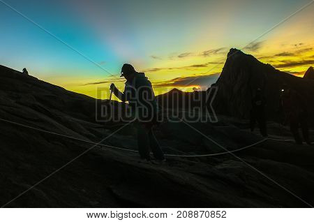 Mount Kinabalu,Ranau,Sabah.Malaysia-March 12,2016:Silhouette climber passing trail to the summit of Mountain Kinabalu during sunrise in Mount Kinabalu,Sabah,Malaysia.