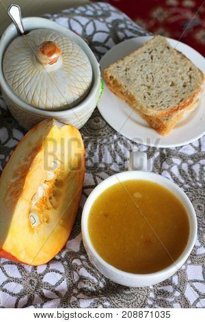 Pumpkin soup in white mug on table. Modern photography. The best for book with recipies.