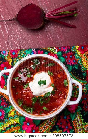 Ukrainian Traditional Borsch. Russian Vegetarian Red Soup  In White Bowl On Red Wooden Background. T