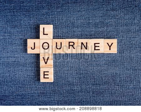 Wooden cubes crossword of Love Journey on Jean fabric background