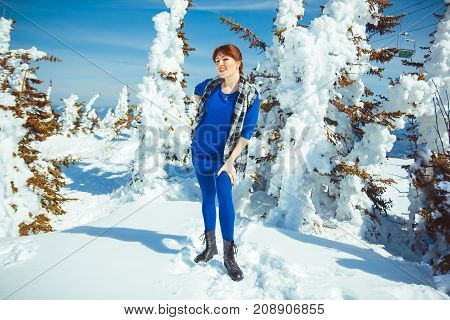 the woman standing in the winter in the mountains, happy in the snow