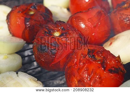Red Tomatoes And Onions On Bbq Grill Close Up