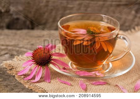 Cup of echinacea tea on old wooden table.