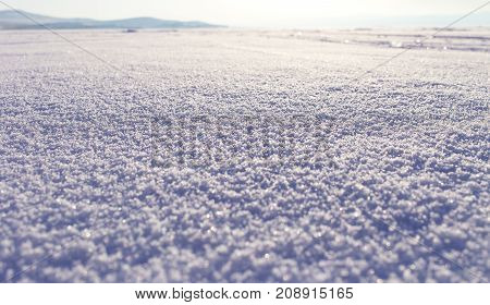 Winter landscape. Snow field sparkling in the sun, surface snow texture. Christmas natural background. Lake Baikal