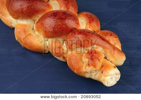makea leipä: golden challah yli sininen puinen levy