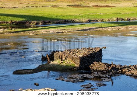 Ruins on the bottom of a dry reservoir in Portomarin Northern Spain.
