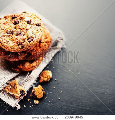 Chocolate chip cookies on dark with place for text freshly baked. Selective Focus with Copy space. Rustic styled image. Heap of tasty cookies