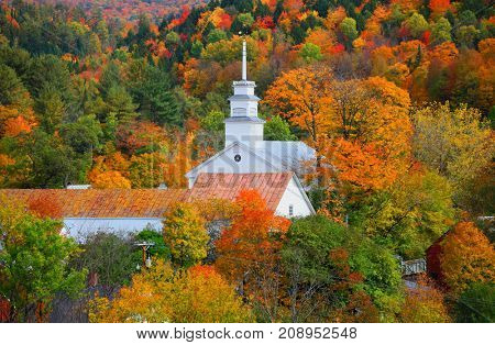 Small church in Topsham village in Vermont in the middle of fall foliage