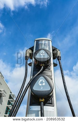 Charging station for zero emission cars on cloudy sky background. Electrical infrastructure for green sustainable future of the planet. EV - electric vehicle charging station. Electric charging point
