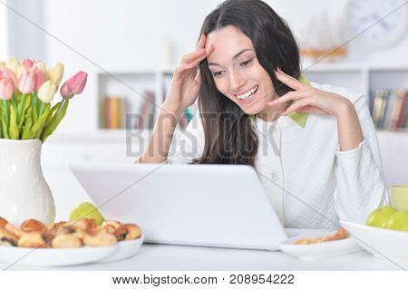 Beautiful  young   woman  using  laptop  at table