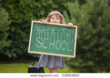 Adorable Smiling Toddler Girl With Back To School Text Blackboard
