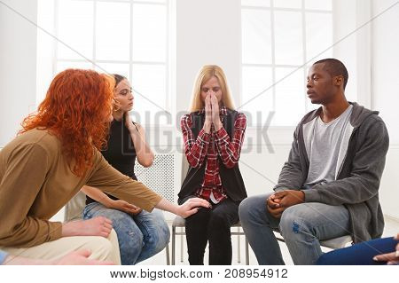 Meeting of support group. Young despaired woman crying during rehab group therapy. Psychotherapy, depression, life issues concept