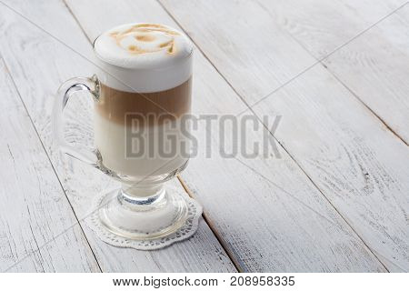 Delicious cappuccino on plank wooden table with copy space