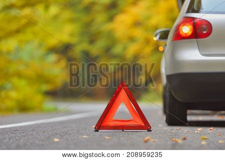 Broken car concept breakdown triangle on road