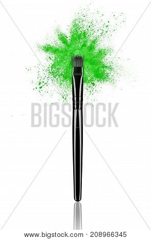 Green make up brush with powder splash close-up isolated on white background