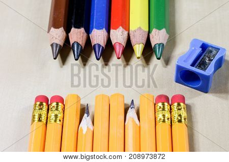 Crayons And Pencil Sharpener On A Wooden Office Table. Crayons With Sharpening Crayons And Pencils O
