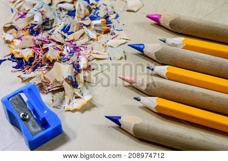 Crayons And Pencil Sharpener On A Wooden Office Table. Crayons With Sharpening Crayons And Pencils O