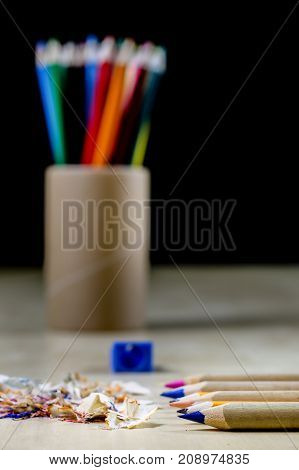 Crayons And Pencil Sharpener On A Wooden Office Table. Crayons With Sharpening Crayons And Pencils O