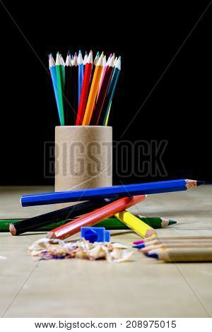 Crayons And Pencil Sharpener On A Wooden Office Table. Crayons With Sharpening Crayons And Pencils O