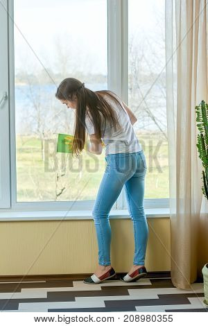 Housewife cleaning a window. Young woman wiping glass. How to simplify housework.