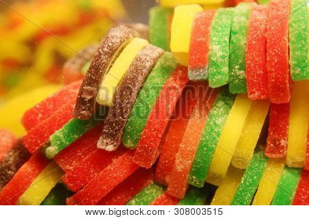 Candy Fruit Slices. Various colors and flavors of imitation fruit slices made from Sugar, and artificial flavors. Fruit Shaped Sugared Candy. 
