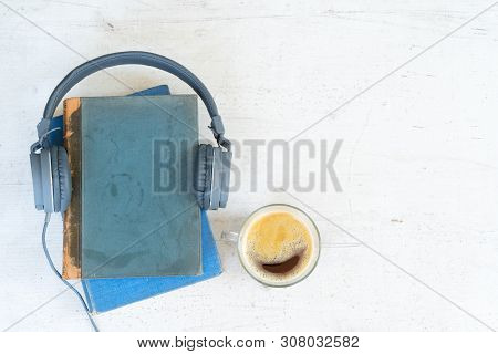 Audio Book Concept. Headphones With Books And Cup Of Fresh Coffee On Wooden Table. Top View With Cop