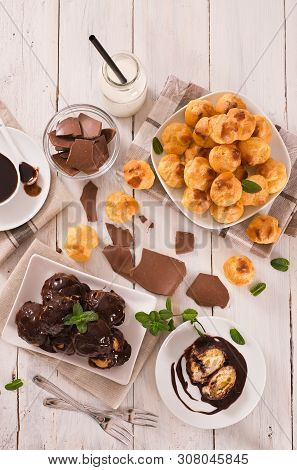 Chocolate Profiteroles With Whipped Cream On White Dish.