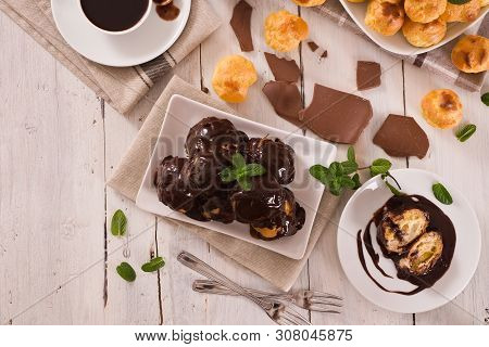 Chocolate Profiteroles With Whipped Cream On White Dish.