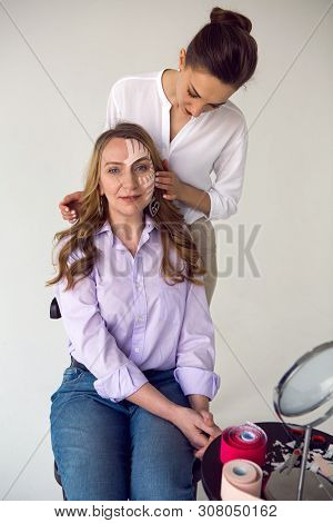 Beautician Aesthetician Glues Kinesio Tape On The Face