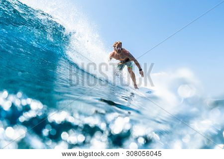 HIMMAFUSHI / MALDIVES - MARCH 08, 2019: Surfer rides barreling crystal clear ocean wave