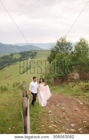 Beautiful Young Wedding Couple Standing On The Green Slope, Hill. Groom And Bride In Carpathian Moun